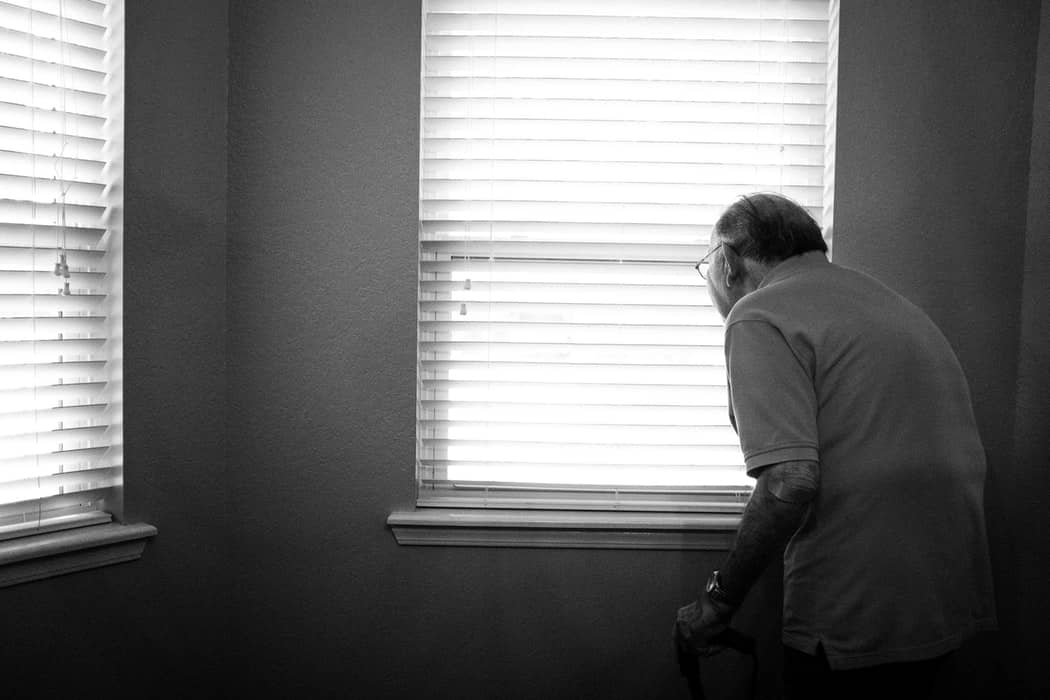 Old Man Looking Outside Of Window