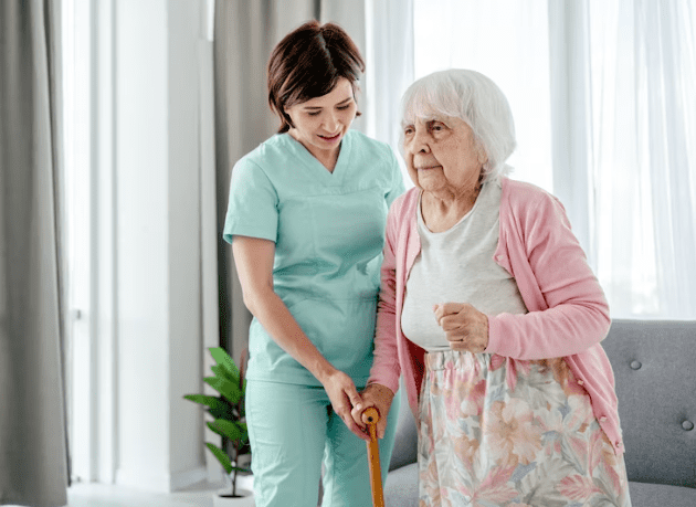 Nurse Helps Elder Woman At Home 24-7 Nursing Care